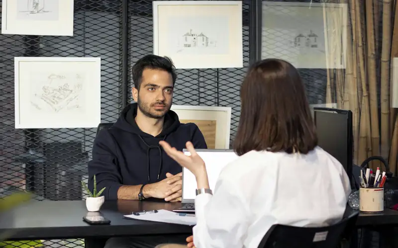 A candidate in conversation with an interviewer across a desk